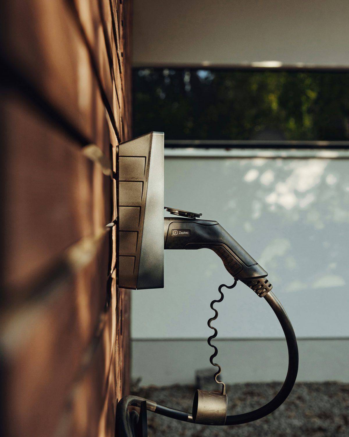 Wallbox an einer Hauswand mit eingehängtem Ladekabel